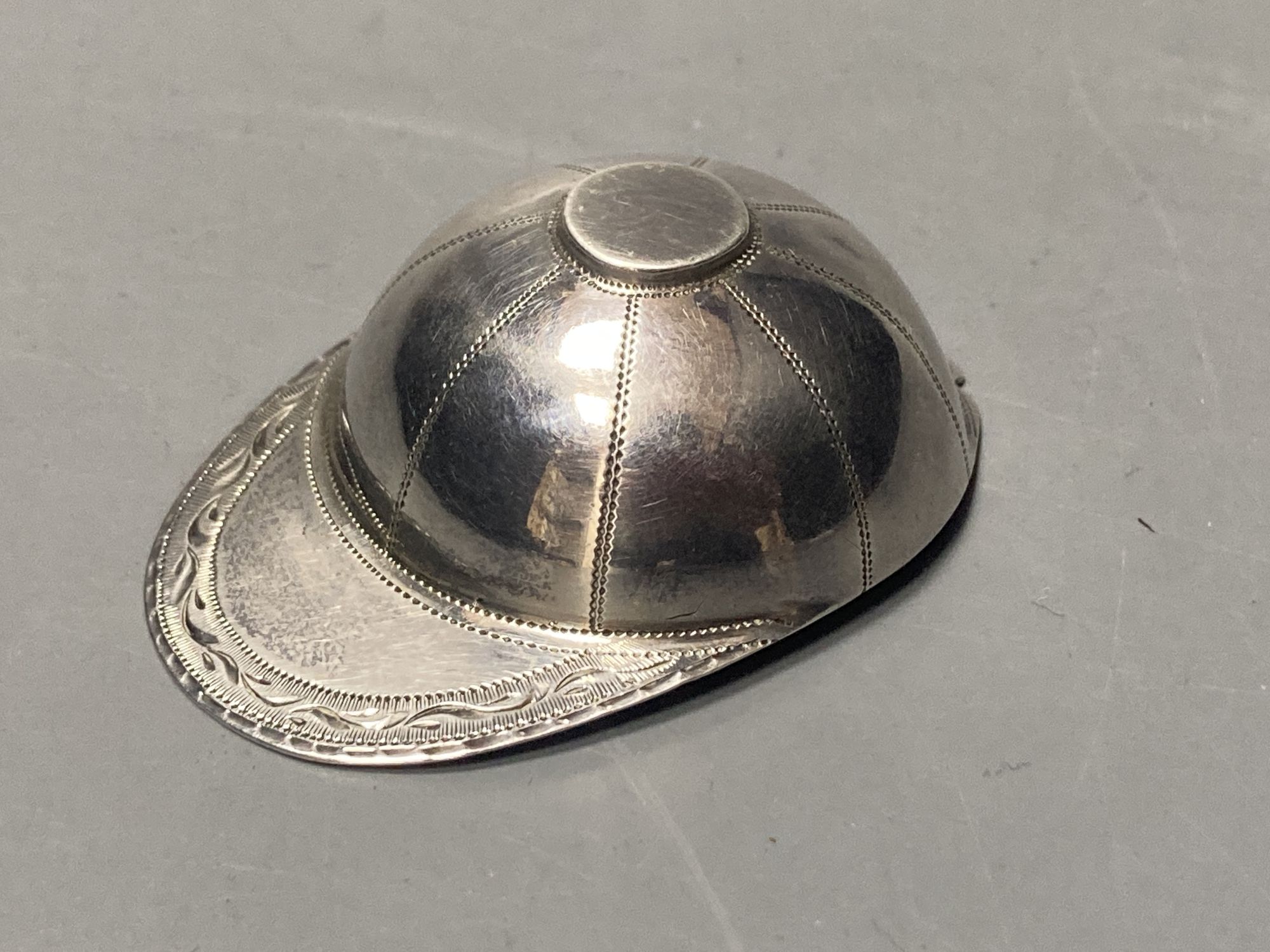 A George III engraved silver novelty caddy spoon, modelled as a jockeys cap, Josiah Snatt, London, 1810, 51mm.